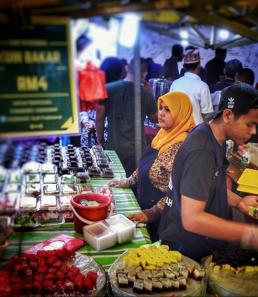 Peniaga kuih memakai sarung tangan di gerai bazar